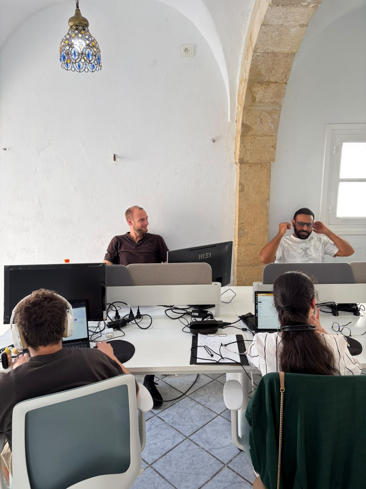 Télétravailleurs dans la salle de coworking aux arches en pierre à Dar Fenina